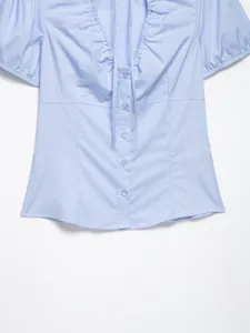 Top in popeline azzurro a maniche corte con scollo arricciato e bottoni frontali.
