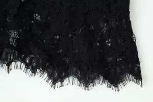 Black lace trim fabric detail view, delicate floral pattern and fringe hem design for apparel.