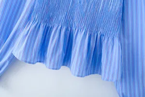 Nahaufnahme der blauen gestreiften Langarmbluse mit elastischem gesmokten Miederteil.