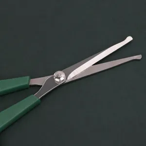Professional pet grooming scissors with metal blade and green handle for easy pet hair trimming.