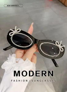 Elegante ovale Sonnenbrille mit Strass-Schleife, schwarze modische Kristall-Sonnenbrille Detail.