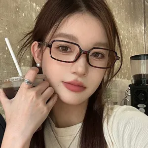 Gros plan détaillé de lunettes de vue carrées élégantes en écaille portées en café tendance.