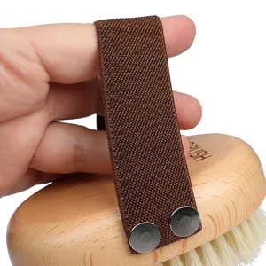 Wooden pet massage bath brush with elastic strap and teardrop shape for grooming pets.