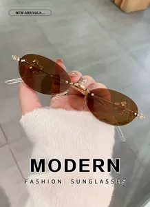 Gafas de sol ovaladas sin montura con patillas de estrás brillantes y elegantes lentes marrones.