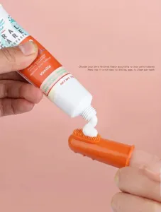 Pet toothbrush and toothpaste detail view, soft silicone finger brush for oral care and cleaning.