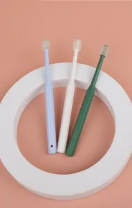 Detail view of soft bristle pet toothbrushes in multiple colors with ergonomic handle.