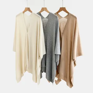 Dettaglio cardigan ponco in maglia con trama morbida ed elegante stile drappeggiato.