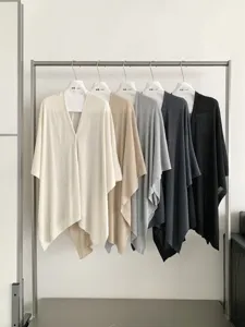 Vista di dettaglio della mantella cardigan in morbido tessuto con drappeggio rilassato.