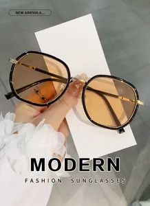 Modische polygon Damen Sonnenbrille mit Schwarz Gold Gestell und braunen UV Schutzgläsern.