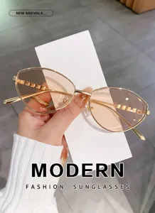 Primer plano de gafas de sol cat-eye de metal con lentes degradadas y diseño elegante.