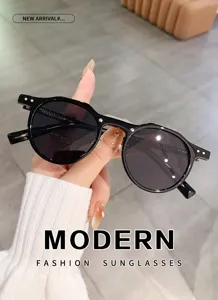 Detail shot of black round fashion sunglasses with stylish metal pin temples and dark lenses.