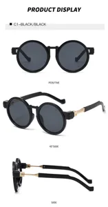Detailaufnahme von Retro Sonnenbrille mit runden schwarzen Rahmen und goldenen Metallbügeln.