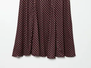 Detailed view of the stylish women's polka dot skirt hem showing fabric drape and pleats.
