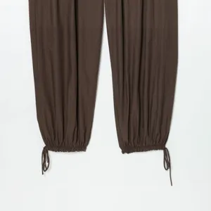 Pantaloni casual marrone scuro con elegante coulisse regolabile sul fondo e vestibilità comoda.