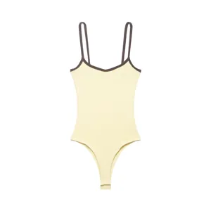 Detail view of the light yellow ribbed bodysuit with dark brown contrast trim and slim straps.