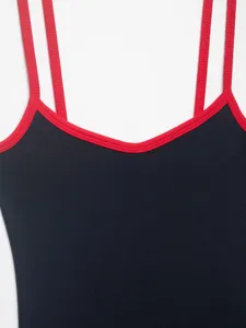 Detail view of women's contrast trim bodysuit with red straps and black ribbed fabric.