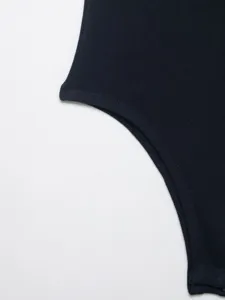 Detail shot of women's ribbed bodysuit, dark color fabric close-up with fine texture.