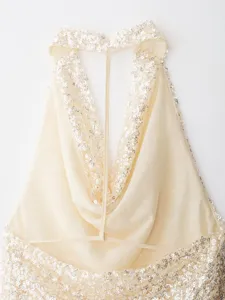 Primo piano sui dettagli eleganti del top halter di paillettes con perline scintillanti.
