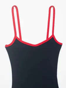 Close-up view of ribbed bodysuit featuring vibrant red contrast straps and trim details.