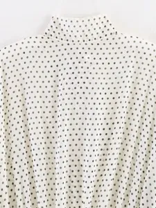 White chiffon blouse back detail with classic black polka dots and high neck design.
