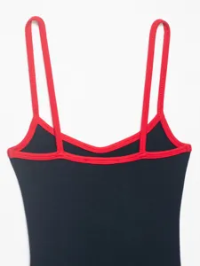 Close-up detail of women's ribbed bodysuit featuring striking contrast red straps and trim.
