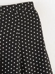 Close-up detail shot of classic black and white polka dot fabric for stylish women's apparel.
