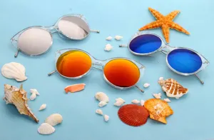 Detail view of trendy cat-eye sunglasses with colorful reflective lenses on blue beach background.