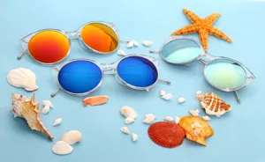 Detailed view of cat-eye sunglasses with colorful reflective lenses on a stylish beach themed scene.