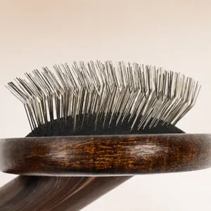 Cepillo carda profesional para mascotas con púas metálicas y mango de madera resistente.