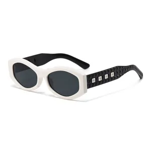 Schicke Sonnenbrille mit dickem, geometrischem Rahmen, weißer Front und nietenbesetzten Bügeln.