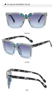Oversized rhinestone sunglasses detail view featuring blue gradient lenses and crystal butterfly.