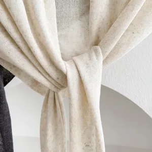 Detalle de chal de mezcla de lino, tejido beige ligero con textura transpirable, accesorio veraniego.