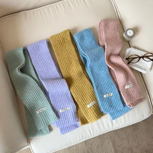 Detailed view of cozy knit winter scarves in five solid pastel colors, soft wool blend fabric.