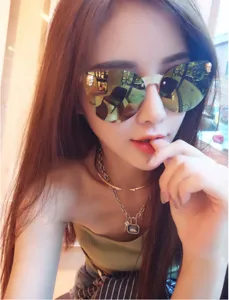 Stylish reflective mirror sunglasses and layered chain necklace detail shot for street fashion.