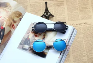 Detail shot of stylish double bridge round sunglasses with mirrored lenses on magazine flatlay.