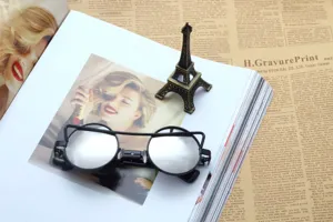 Detailed view of trendy black cat-eye sunglasses with reflective lenses, stylish street fashion.