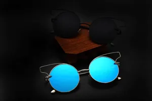 Vue détaillée de lunettes de soleil rondes tendance avec verres réfléchissants bleus et montures.