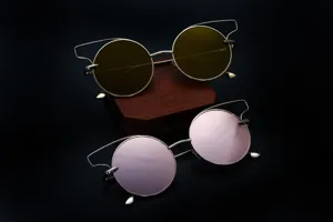 Vue détaillée de lunettes de soleil rondes tendance avec monture géométrique et verres miroir.