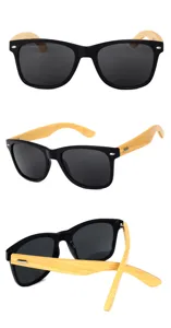 Vista detallada de gafas de sol con montura negra y patillas de bambú natural respetuosas con el medio.