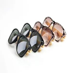 Vista detallada de gafas de sol retro cuadradas con patillas de bambú y monturas elegantes.