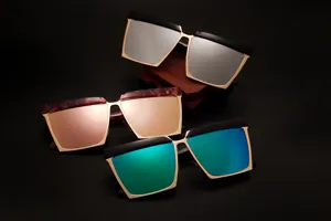 Occhiali da sole quadrati oversize con montatura in metallo dorato e lenti riflettenti.