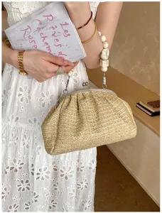 Vue détaillée d'un sac pochette en paille chic avec poignée perlée pour le style estival idéal.
