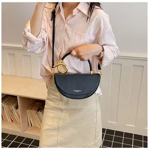 Detailansicht der stilvollen Halbmond-Satteltasche aus schwarzem Leder mit Goldgriff.
