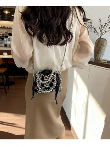 Detailed view of a chic black beaded crossbody pouch with silver metallic mesh and delicate chain.