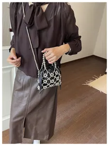 Stylish metallic beaded net crossbody bag with black inner pouch, chic fashion accessory detail.