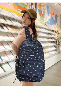 Detail of navy blue star print backpack carried by a student in a bookstore setting.