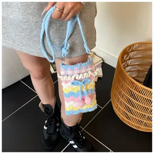 Handgefertigte Häkel-Handytasche mit Kirschakzenten und bunten Mustern.