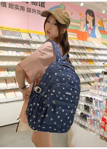 Navy blue student backpack with white star patterns and large capacity, ideal for school girls.
