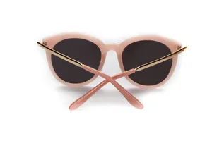 Rosa runde Sonnenbrille mit goldenen Metallbuegeln und dunklen Glaesern fuer Damen Alltag.