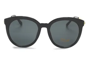 Nahaufnahme einer schwarzen Oversized-Sonnenbrille mit markanten goldenen Bügeldetails.